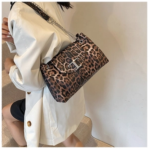 Detail view of leopard print shoulder bag with silver chain strap and T-shaped metal buckle