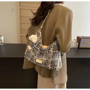 Detail of canvas bucket bag with geometric pattern and cute plush cloud pendant