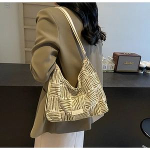 Detailed close-up of large canvas bucket bag featuring geometric patterns and leather straps