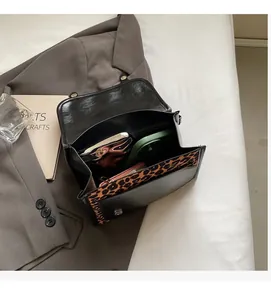 Internal view of leopard print shoulder bag showing large capacity and metal buckle