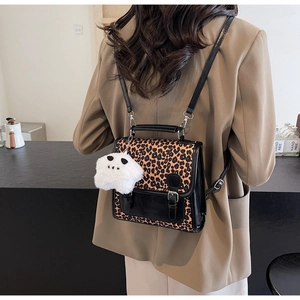Detail view of mini leopard print backpack with star plush keychain and leather straps