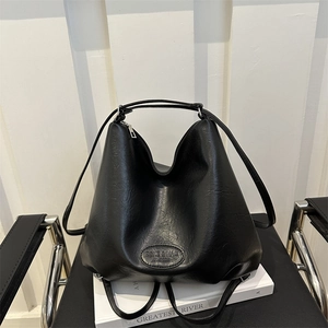 Large black leather tote bag with logo on white book, minimalist commuter style 2024