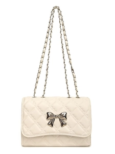Quilted cream shoulder bag with silver bow hardware and metal chain strap on white background