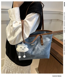 Borsa tote in denim blu con manici in pelle marrone e ciondolo a nuvola in peluche