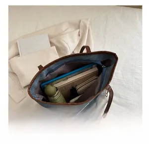 Interno spazioso della borsa tote in denim blu con tablet, libri e ombrello inclusi
