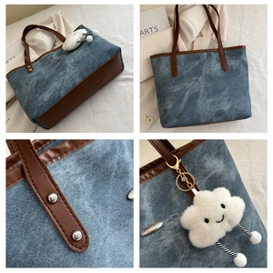 Dettaglio della borsa tote in denim con cinturini in pelle e ciondolo a nuvola