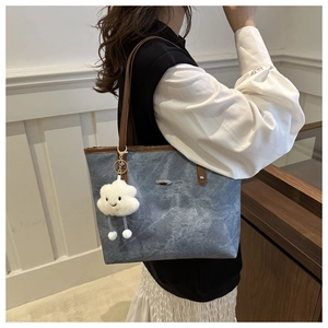 Borsa tote in denim blu con tracolle marroni a contrasto e ciondolo di peluche bianco