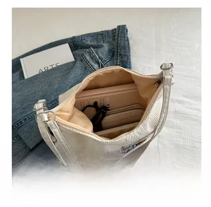 Vue détaillée du sac cabas en velours côtelé blanc montrant le grand compartiment interne