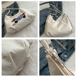 Gros plan du tissu en velours côtelé blanc et broderie de teckel sur le sac à bandoulière