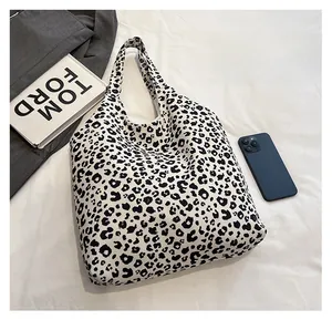 Detail view of large leopard print canvas tote bag with fashionable integrated handles
