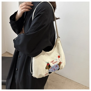 Gros plan du sac bandoulière en velours côtelé crème avec broderie chien et texte Happy Summer