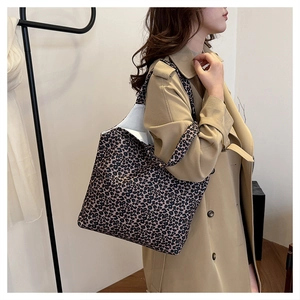 Detailed side view of large leopard print canvas tote bag styled with a trench coat