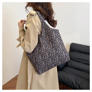 Detailed view of the large leopard print canvas tote bag worn by a model in a home setting