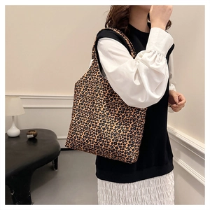Detailed view of large leopard print tote bag carried on shoulder for daily commute