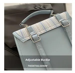 Detail view of adjustable silver buckle and striped fabric on a light blue backpack