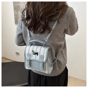 Detail showing embroidered black dog on a blue striped mini backpack for women