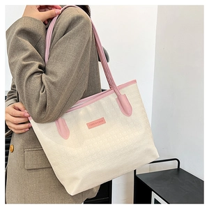Detail der cremefarbenen Tragetasche mit rosa Besatz und FASHION & BAGS Logo-Schild