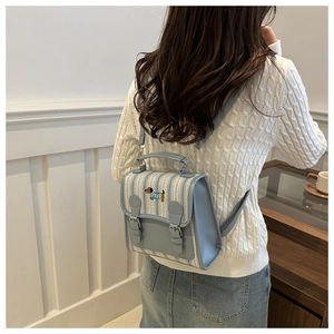 Detail of blue striped mini backpack featuring a small dog embroidery and PU leather straps