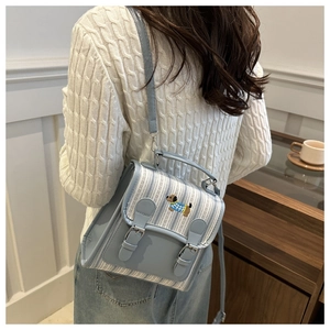 Detail of blue striped mini backpack with cute dachshund embroidery and adjustable straps