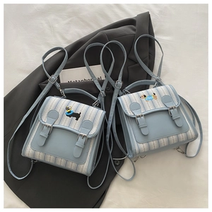 Detail of light blue plaid mini backpack with cartoon dachshund embroidery and pin buckle