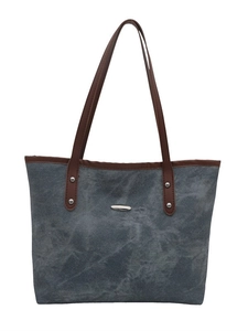 Blue denim tote bag with brown leather straps and silver oval metal plate detail