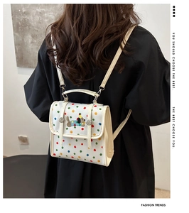 Detail of white canvas backpack with colorful polka dots and cute dog embroidery