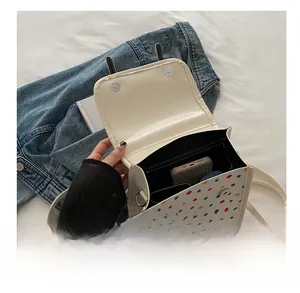 Top view of white crossbody bag with multi-color dots showing phone storage capacity