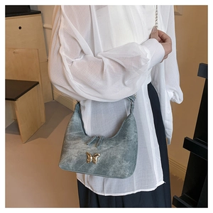 Detailansicht der Halbmond-Tasche mit blauer Vintage-Textur und goldenem Schmetterlingsdekor