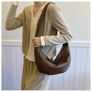 Minimalist brown PU leather crescent hobo bag with wide shoulder strap on model