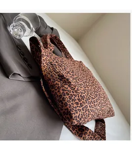 Détail d'un grand sac cabas léopard avec larges bandoulières dans un décor de mode chic