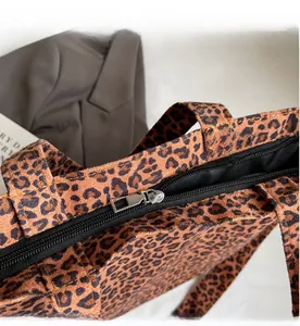 Gros plan sur la fermeture éclair fluide et la doublure noire du sac cabas léopard