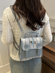 Blue plaid mini backpack with dachshund embroidery shown from a back-wearing perspective