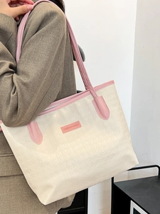 Große beige Tragetasche mit rosa Besatz und Prägemuster auf der Schulter des Models