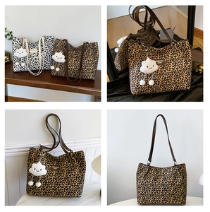 Detail of leopard print tote bag with brown straps and white cloud plush charm