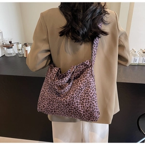 Détail d'un grand sac cabas en toile à imprimé léopard violet avec bandoulière large