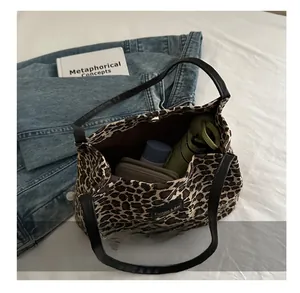 Interno spazioso della borsa tote leopardata che mostra la capacità per gli oggetti quotidiani