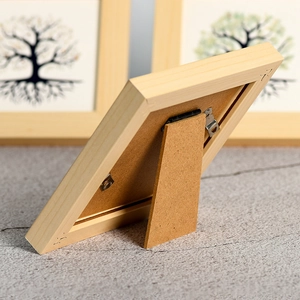 Back view of natural wood photo frame featuring foldable stand and hanging hardware