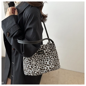 Dettaglio della borsa tote leopardata con manici neri e patch logo alla moda