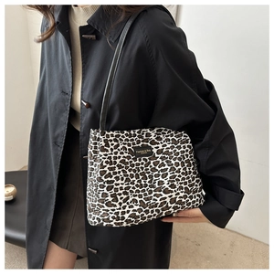 Dettaglio della borsa tote leopardata con toppa in pelle nera e spalline sottili