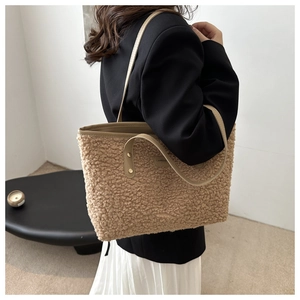 Detailed texture of khaki teddy faux fur tote bag with brown leather handles and rivets
