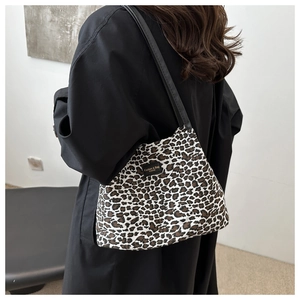 Dettaglio borsa shopper leopardata con etichetta in pelle e sottili manici neri