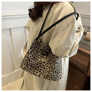 Dettaglio della borsa tote in tela leopardata con spalline nere ed etichetta