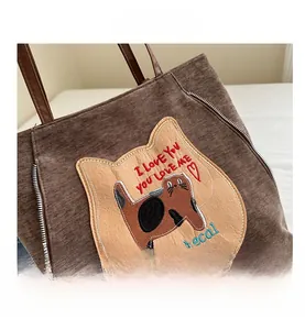 Close-up of brown canvas tote with cute cat applique and decorative side zippers