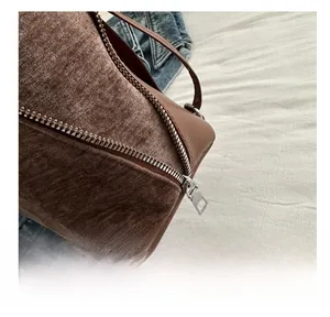 Macro detail of brown corduroy texture and silver metal zipper on a large tote bag