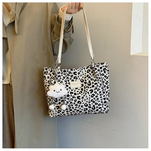 Close-up of leopard print tote bag with white straps and cute cloud plush charm