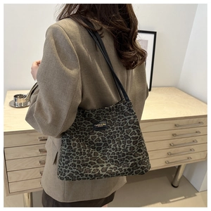 Dettaglio della borsa tote leopardata con targhetta logo nera e sottili spalline chic