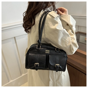 Detail of black vintage bowling bag with gold buckle pockets and long double handles