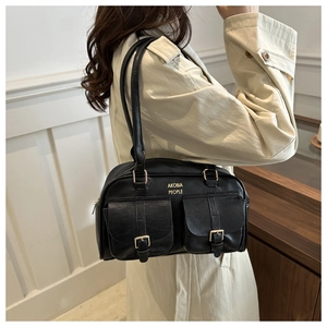 Detailed view of black leather handbag featuring dual pockets and gold metal hardware