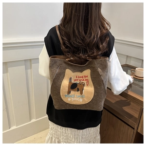 Detailed view of brown tote bag with cute cat embroidery and student style design