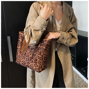 Dettaglio della borsa tote leopardata con logo FASHION in metallo e tracolla marrone